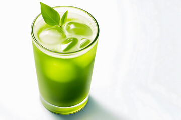 Glass of green juice with ice and fresh green leaves on white background