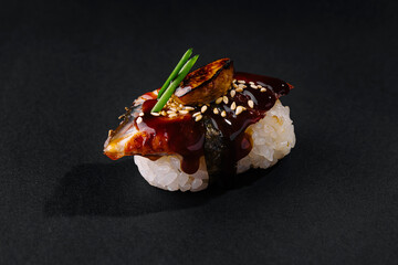 Gourmet unagi nigiri sushi on dark backdrop
