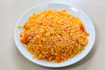 Traditional turkish bulgur pilaf with tomato sause in plate (Turkish name; bulgur pilavi, meyhane pilavi) Pirinc pilavi. Pilavustu tavuk, nohut, kuru fasulye, ciger.