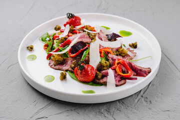 Gourmet beef carpaccio salad on white plate