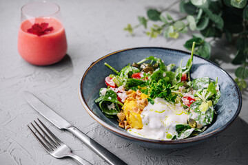 Fresh garden salad with yogurt dressing on textured table