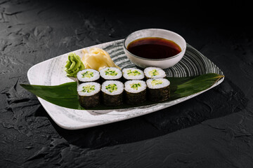 Fresh avocado sushi roll on slate background
