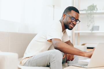 Smiling African American Freelancer Working on Laptop in a Modern Home Office