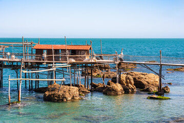 Traditional wooden fishing house with a net near sea coast - 789939517