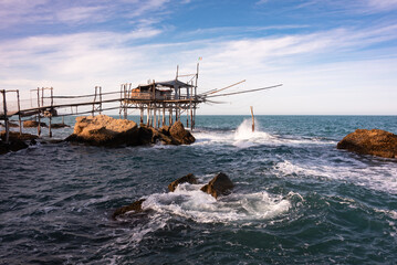 Traditional wooden fishing house with a net near sea coast - 789939984