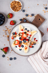 Healthy Banana Split Breakfast with Yogurt, Granola and Fresh Berries