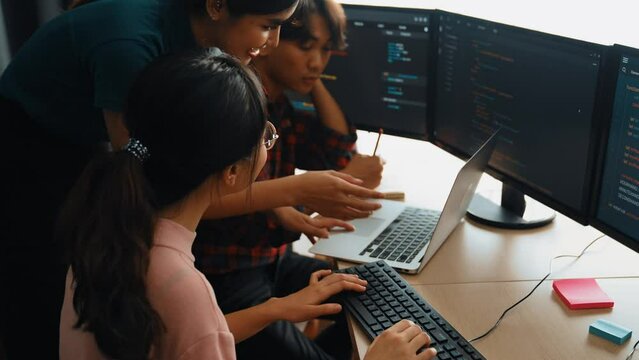 Slow motion back end software developer engineer for computer programming working together on debugging writing computing code, solving complex algorithms display on monitor in office. Burgeoning