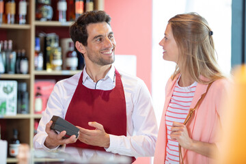 wine worker taking credit-card from customer at wine store