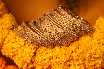 stone studded intricate bangles spread on yellow marigold flowers