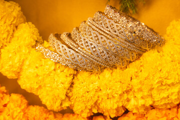 stone studded intricate bangles spread on yellow marigold flowers