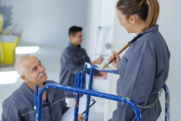 trainee female painter on scaffolding platform