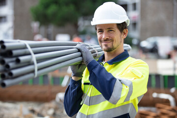 smiling worker carrying corrugated conduit
