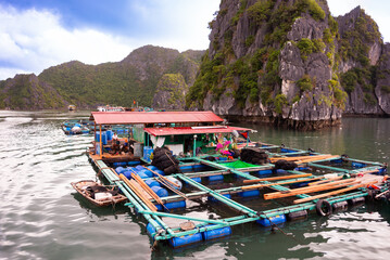 Floating fishing village in sea bay in Vietnam, boats and islands