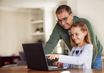 Father, girl and laptop for remote learning in home, internet and school website or online homework. Daddy, daughter and help with lesson at table, education and studying or teaching child o point