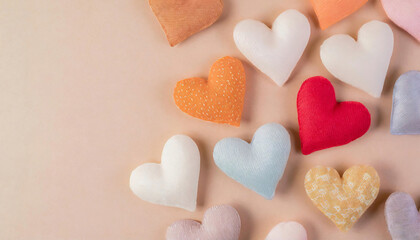 Obraz premium Collection of colorful fabric hearts shaped pillow on a soft pastel background, minimalist composition.