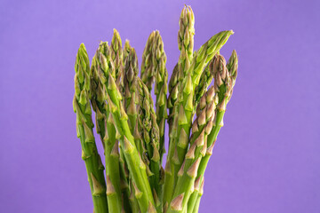 Vibrant green asparagus contrast beautifully against a rich purple background. Perfect for culinary...