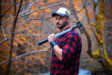 Portrait of Handsome Young Man with Axe and Checkered Shirt in Foggy Autumn Forest - 789964946