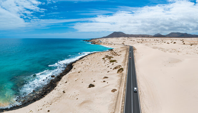 Aerial high level panoramic view of the sand dunes and road between the coast and Parque Natural sand dunes heading to Corralejo Fuerteventura  Canary Islands Spain