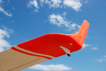 tip of the wing of a gliding airplane, marked with bright orange neon color