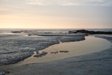 A vast body of water bordered by rocky shores and sandy beaches