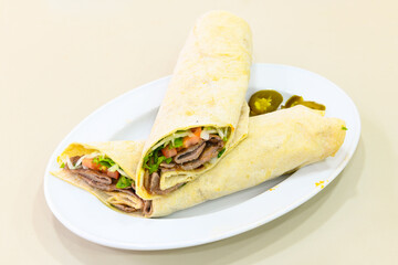 Lavash doner kebab ( zurna et tavuk doner durum )  or shawarma sliced in plate isolated. 