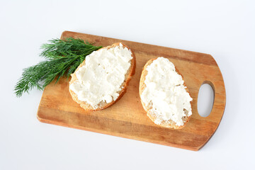 a wooden cutting board with bread slices with ricotta isolated