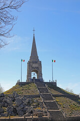 Tonezza, VI, Italy - April 14, 2024: long  stoned Staircase and Italian flags and the spire of the...