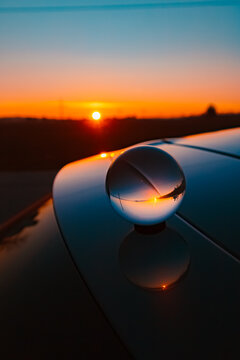 Crystal ball sunset shot with reflections on a car roof at Huett, Eichendorf, Dingolfing-Landau, Bavaria, Germany