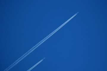 two planes in the sky, two parallel airplane tracks in the blue sky, contrails - obrazy, fototapety, plakaty