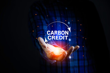 Carbon credit icon at hand.  Carbon credit market and net zero concept. Trading to offset greenhouse gas emissions into the environment. Can be traded on the carbon market.