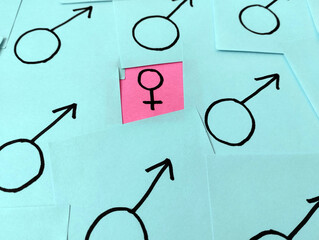 Sticky notes in pink and blue that show how women are barely visible and important jobs are given...