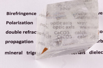 Optical birefringence demonstrated using a text using a natural double spar calcite crystal