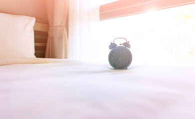 Blue alarm clock on the bedroom after waking up, sunlight in morning