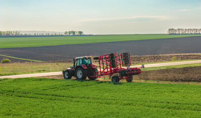 Obraz premium tractor transports a folded plow. before sowing the crop, close up