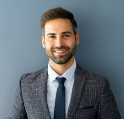 Portrait of a Smiling Businessman in Professional Attire Against a Flat Background