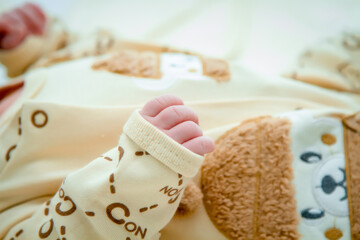 hand of a dressed newborn baby