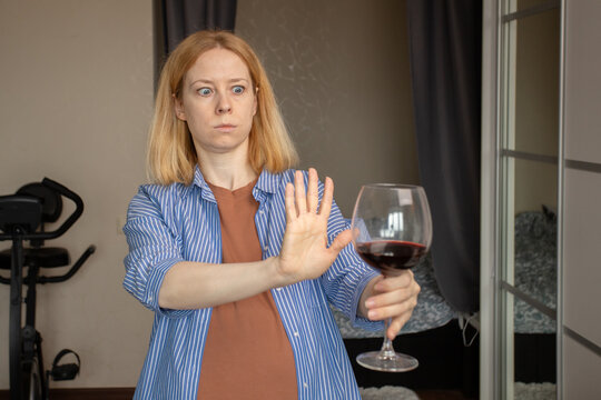 abstinence alcohol, stop liquor, pregnant woman shows a sign of rejection of wine with her hand, refusal of alcoholism