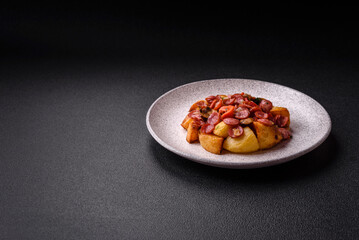 Grilled potatoes cut into slices with hunting sausages with garlic, onion