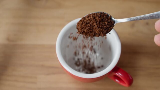 Slow Motion of Instant Coffee Pieces Falling From Spoon in Coffee Cup. coffee powder falling from the spoon. Fresh Morning Hot Coffee Close Up. Footage of a B-roll scene in slow motion (4K).