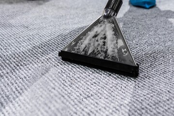 Janitor cleaning carpet rug with vacuum