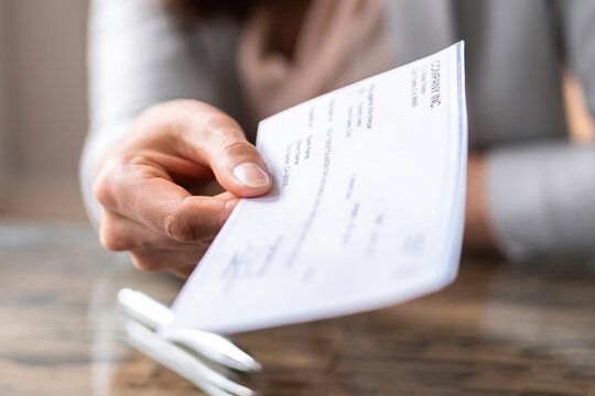 Hand giving paycheck, check, cheque