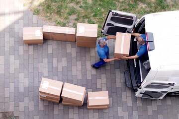 Movers carrying heavy boxes while moving