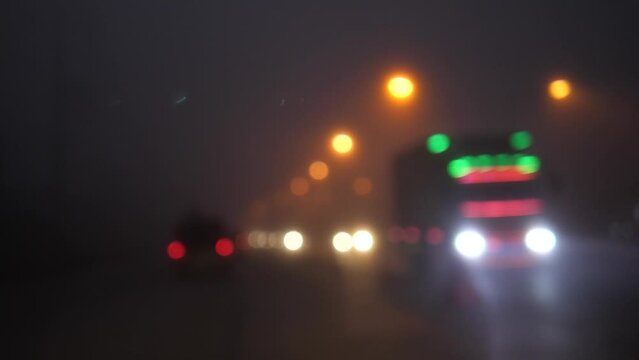 Car Headlights and Streetlights Blurred on Night Road with Hazy Atmosphere