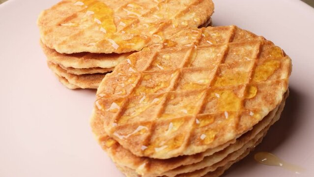 Close-up Belgium Crispy Butter Waffles pouring honey on 360 degree rotating plate