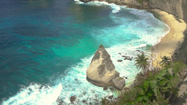 Cliff in Sumatra washed by azure wavy ocean water.