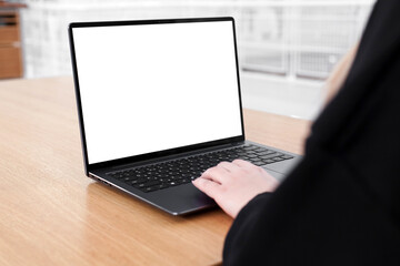 Young white woman working on computer with blank copy space screen on table in home office. close...