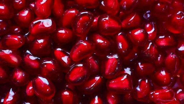 Bright red pomegranate seeds circle rotation close up top view