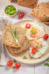 British breakfast with fried eggs, bread and chive.