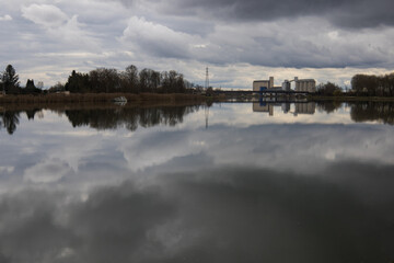 Fototapeta premium vue sur la rivière la Saône en Côte d'or en Bourgogne à Losne et Saint-Jean-de-Losne un jour d'hiver nuageux avec des reflets sur les eaux calmes du fleuve