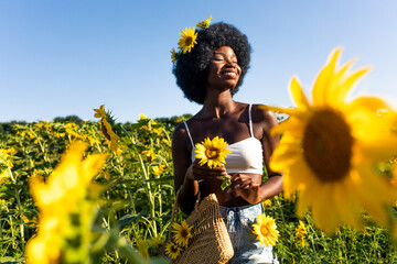 Beautiful afro american woman in a sunflowers field